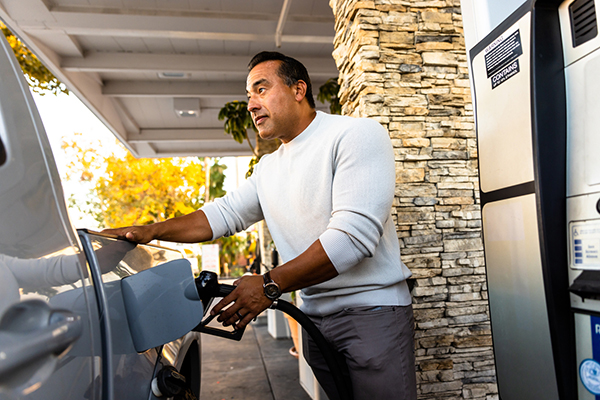 Man pumping gas at gas station in US