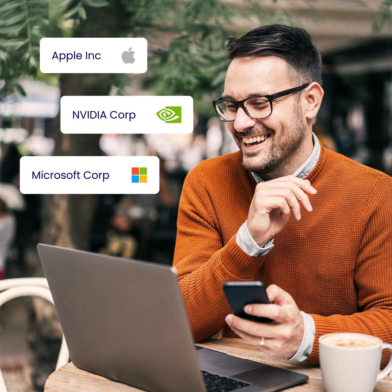 Man smiling at laptop holding a mobile device and graphics showing graphics for Apple, Nvidia and Microsoft.