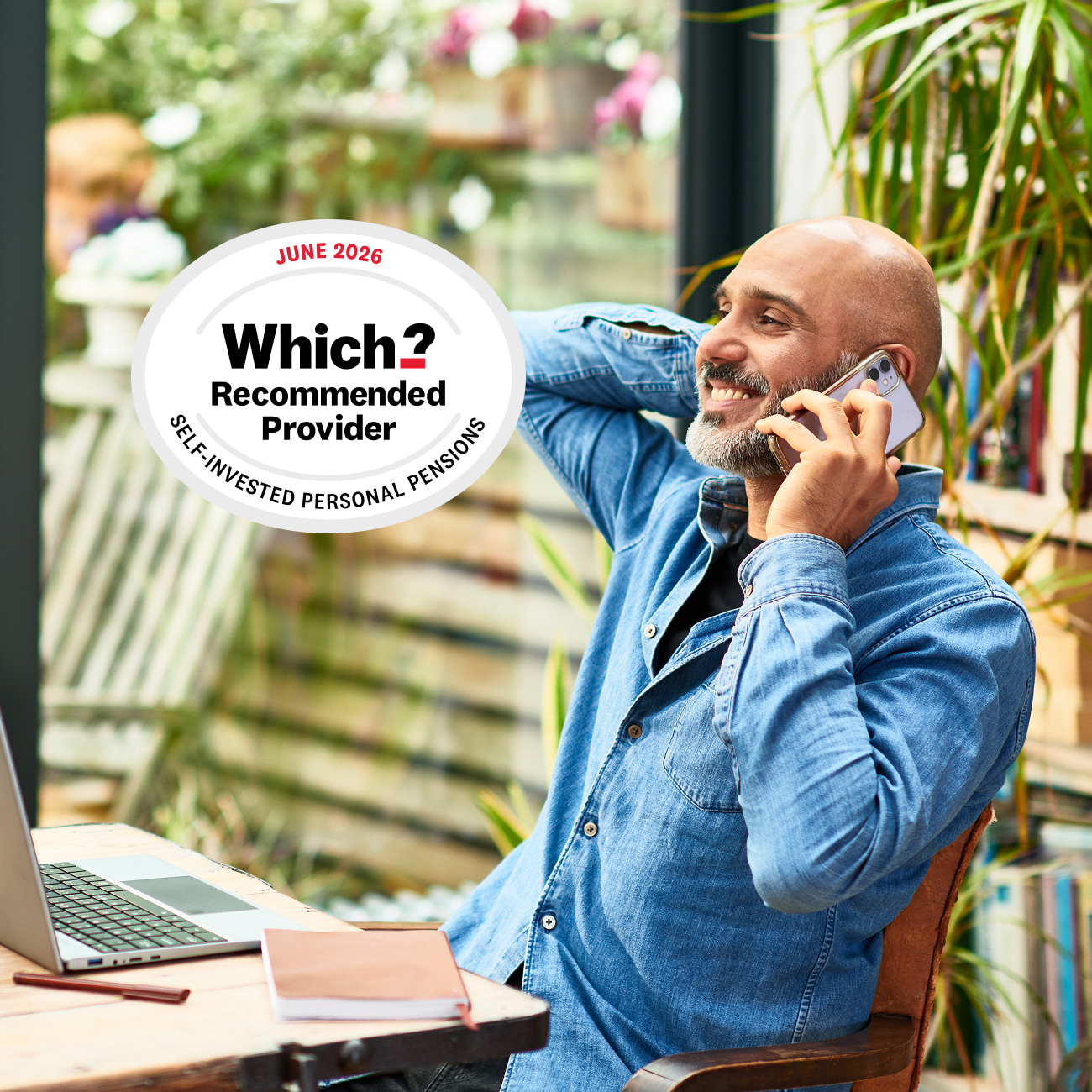 Man smiling on the phone with laptop and 2026 Which? Recommended Provider award