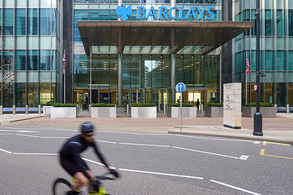 Cyclist going past Barclays global headquarters in Canary Wharf, Getty