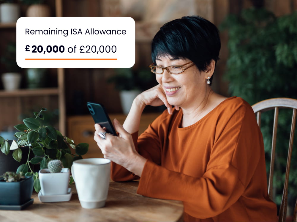 ISA allowance used, woman looking at mobile whilst sat at table