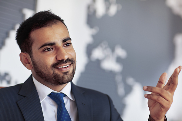 Fund manager talking with a world map behind him