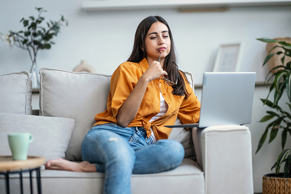 Woman thinking while working on laptop