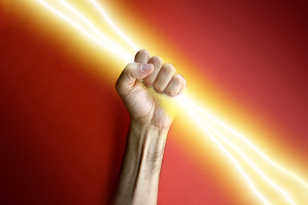 Man's hand holding lightning bolt