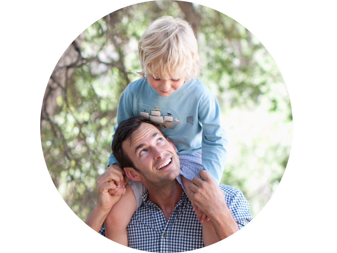 Father looking up at his young son on his shoulders
