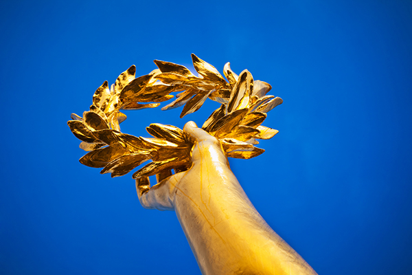 Hand holding gold laurel crown