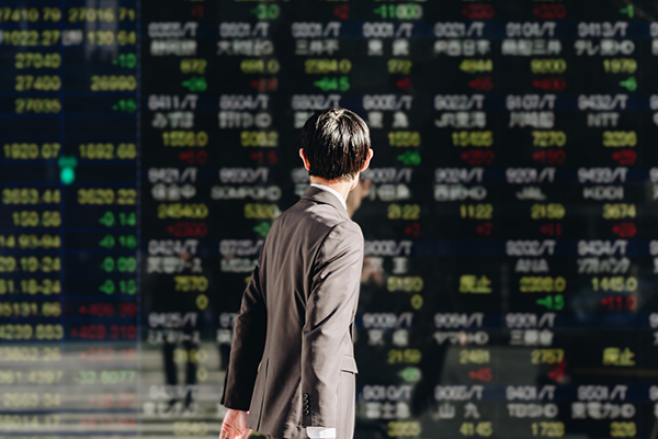 A Japanese man looking at stock market data