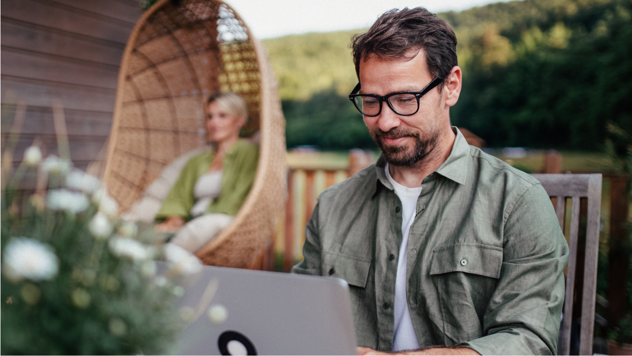 Man outdoors looking at his laptop