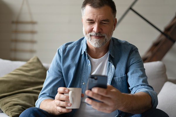 Investor sitting on sofa looking at smartphone