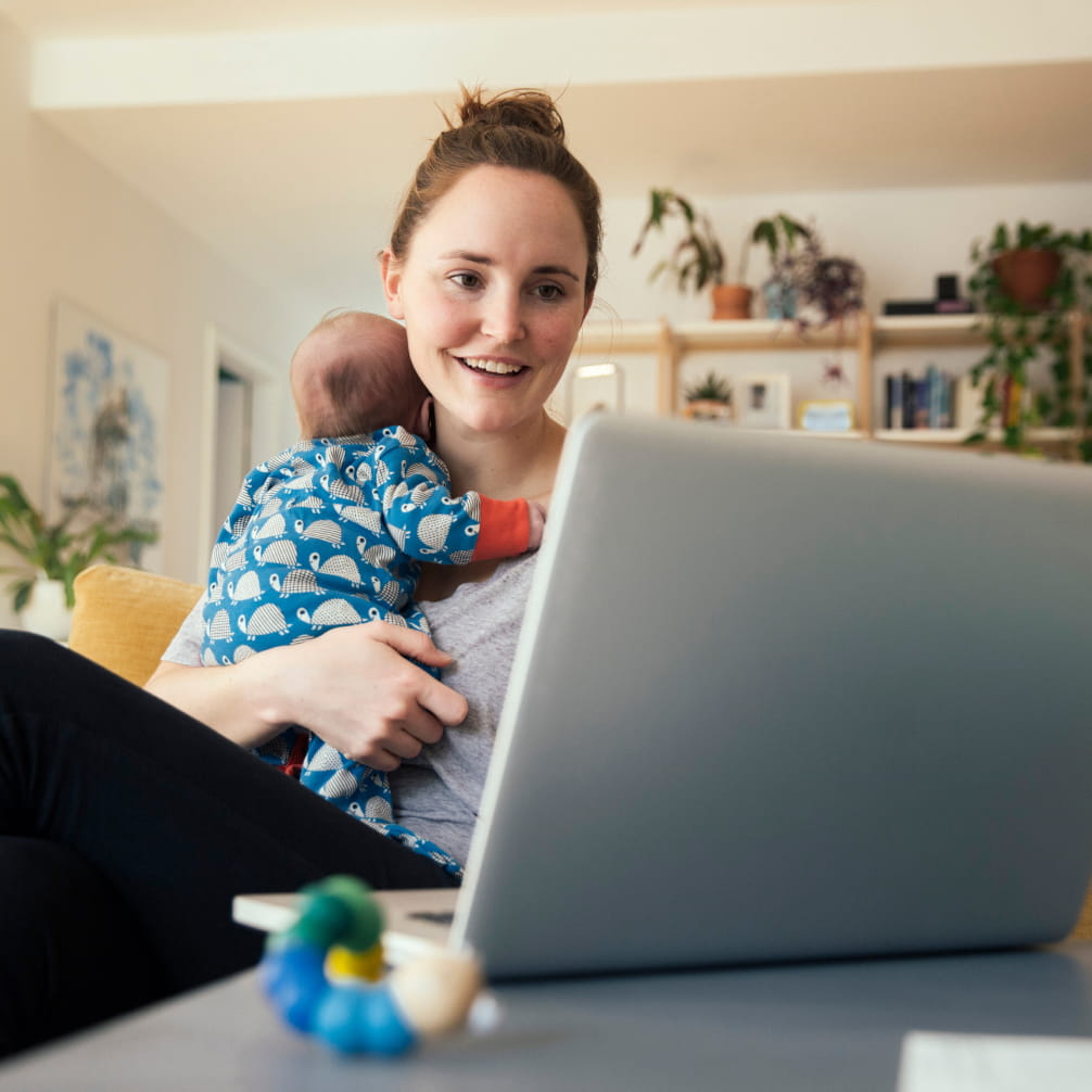 Woman with baby looking at laptop