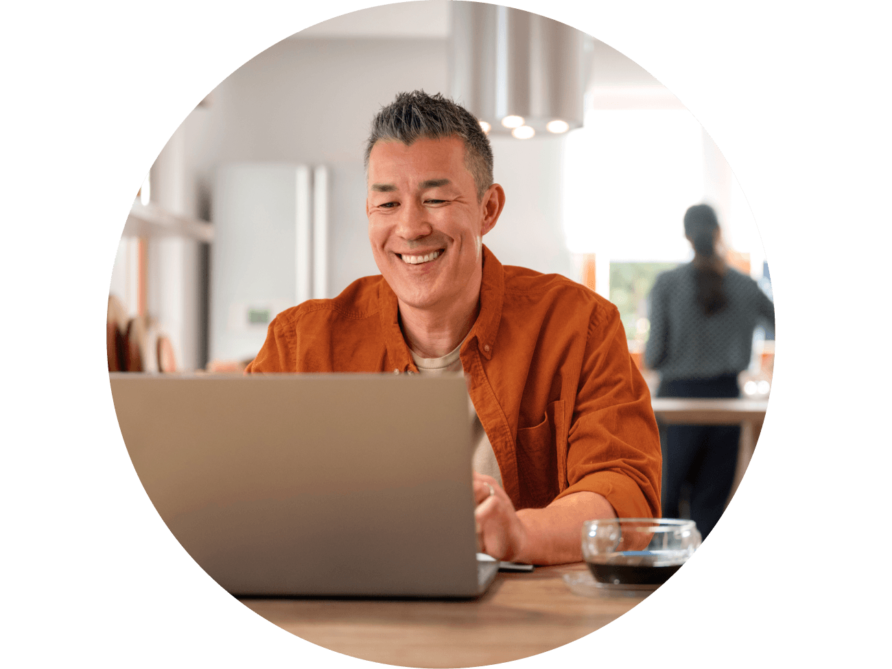man-in-kitchen-with-laptop-happy-orange-shirt
