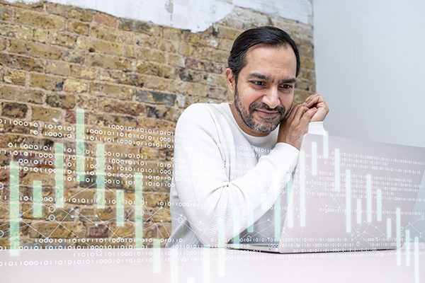 Man studying shares on home laptop
