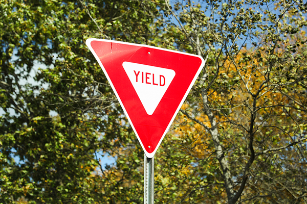 Yield sign in front of trees